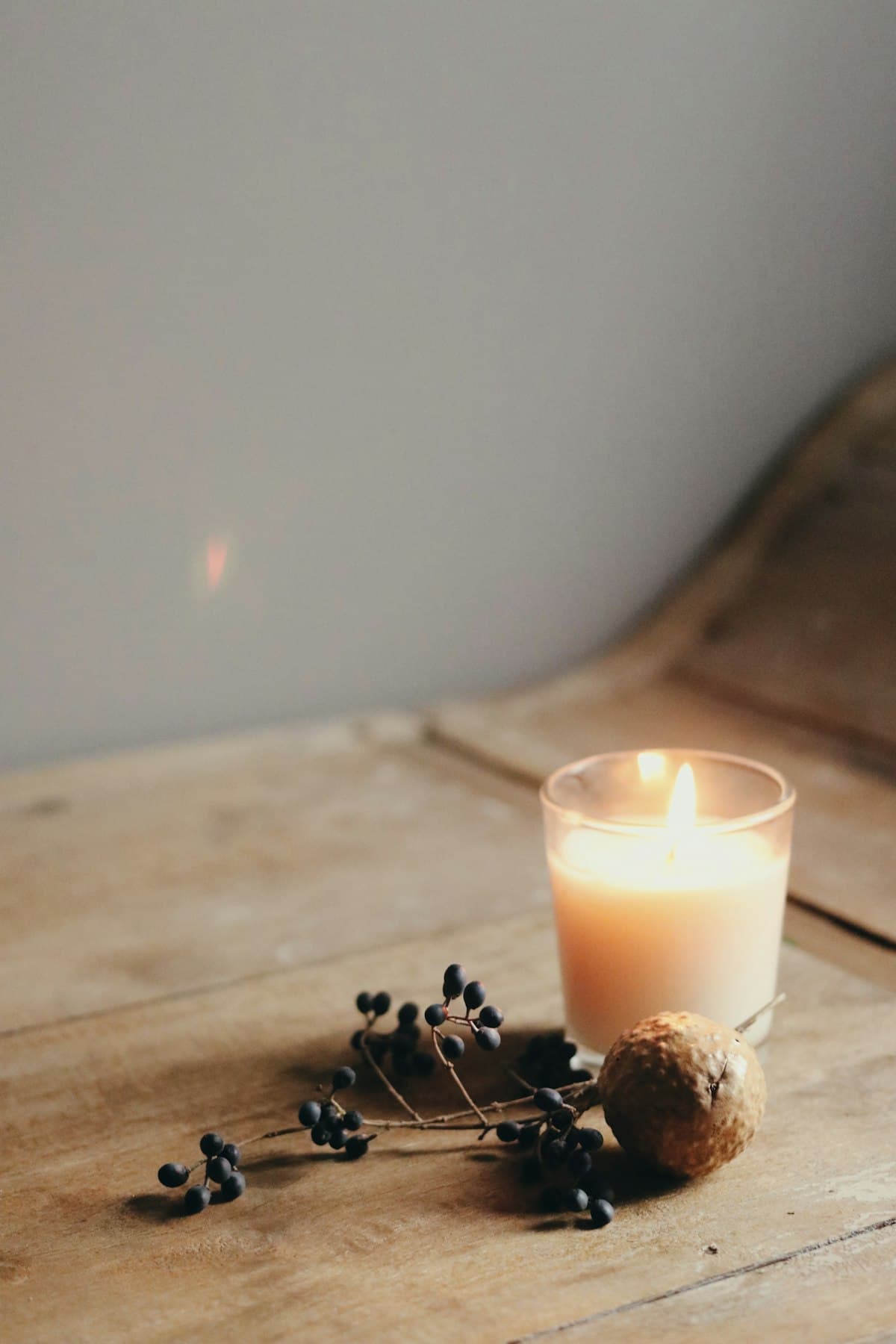 Glowing candle on rustic wooden table